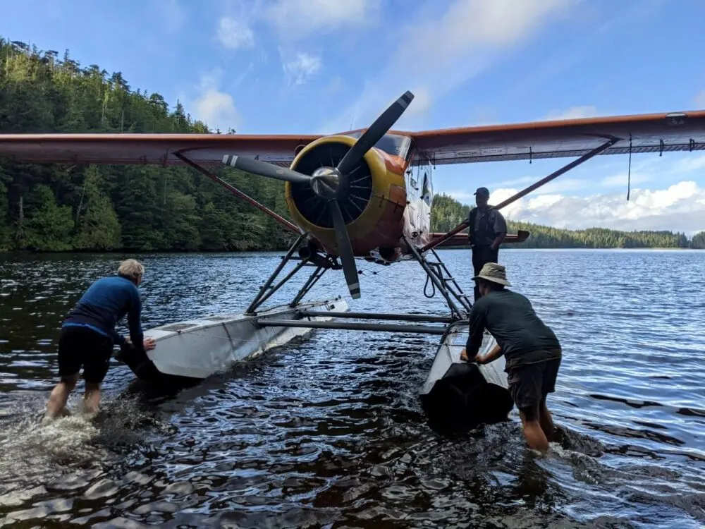 Back view of two hikes pushing seaplane away in Starfish Lagoon