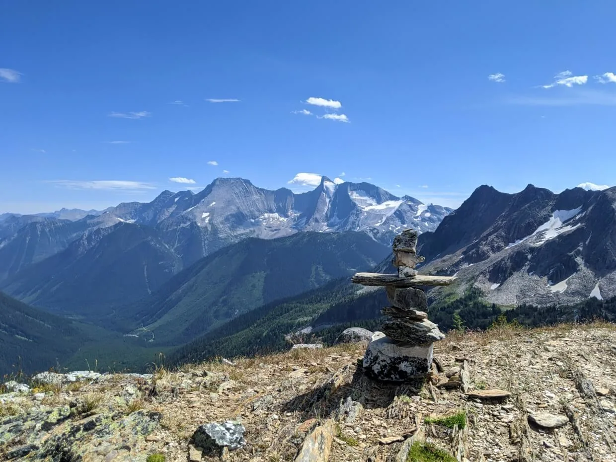 Classic rock inukshuk in front of mountain scenery on Jumbo Pass Trail