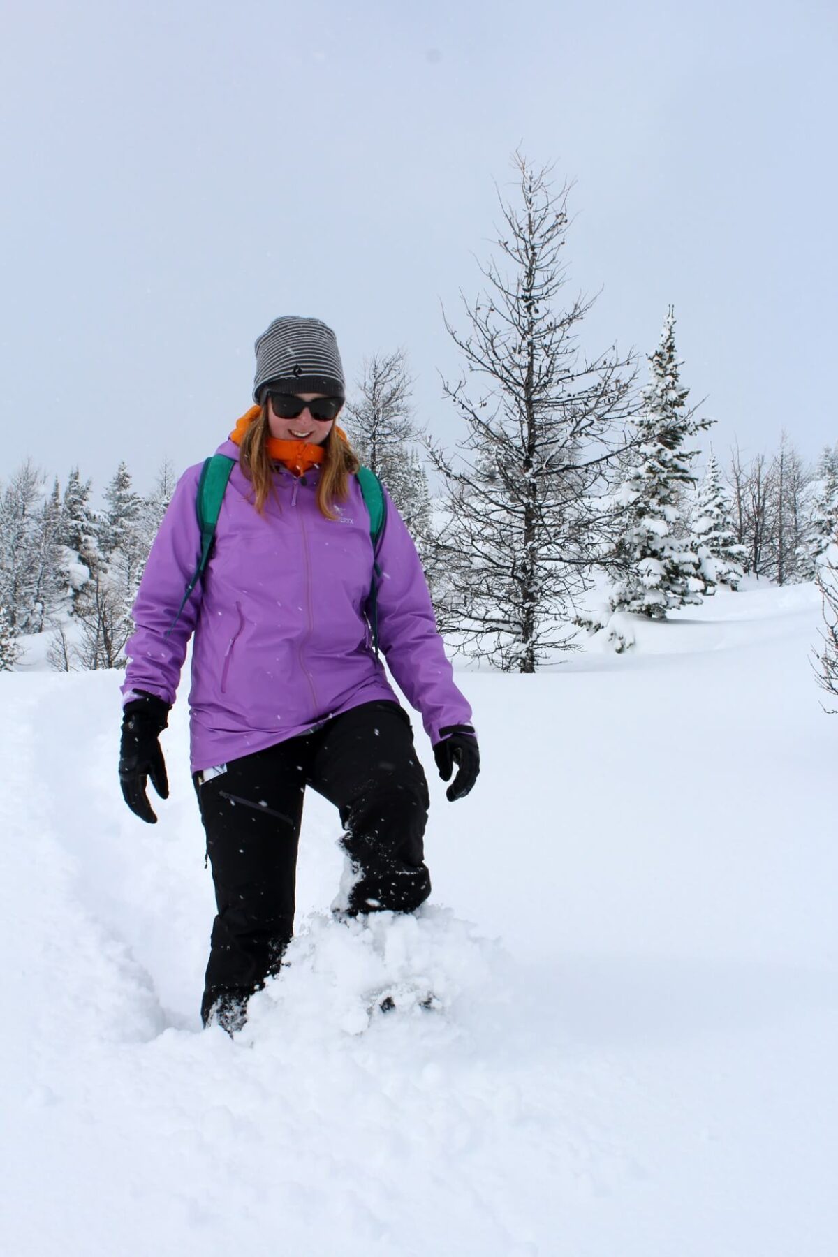Front view of Gemma snowshoeing through deep powder at Sunshine Meadows, one of the best places to go snowshoeing in Banff