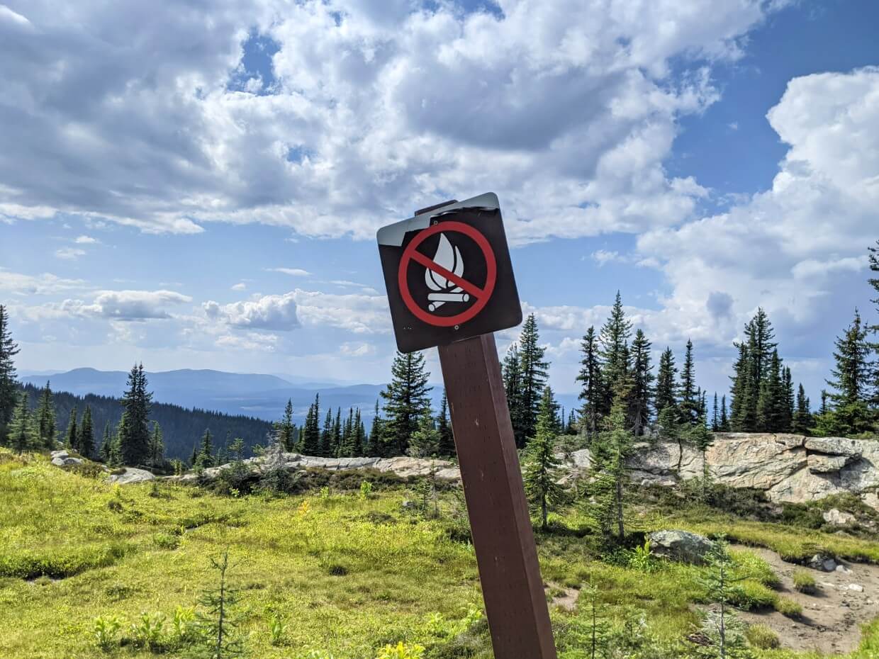 Close up of wooden 'no campfires' sign with campfire symbol and red strike through it, at Sheila Lake backcountry campground on Trophy Meadows Trail in Wells Gray Provincial Park
