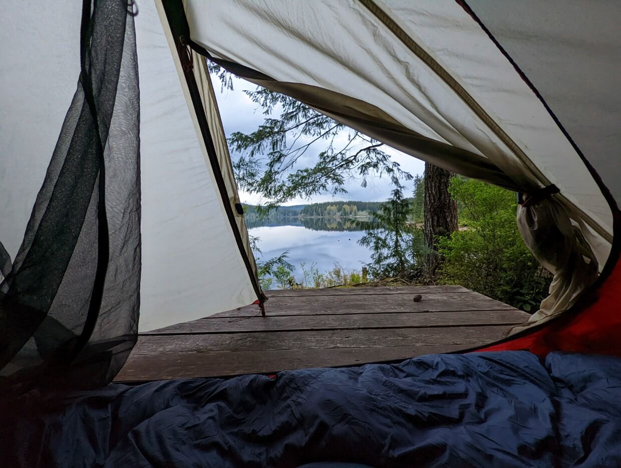 View looking out from inside a tent. Just beyond the tent is Fry Narrows.
