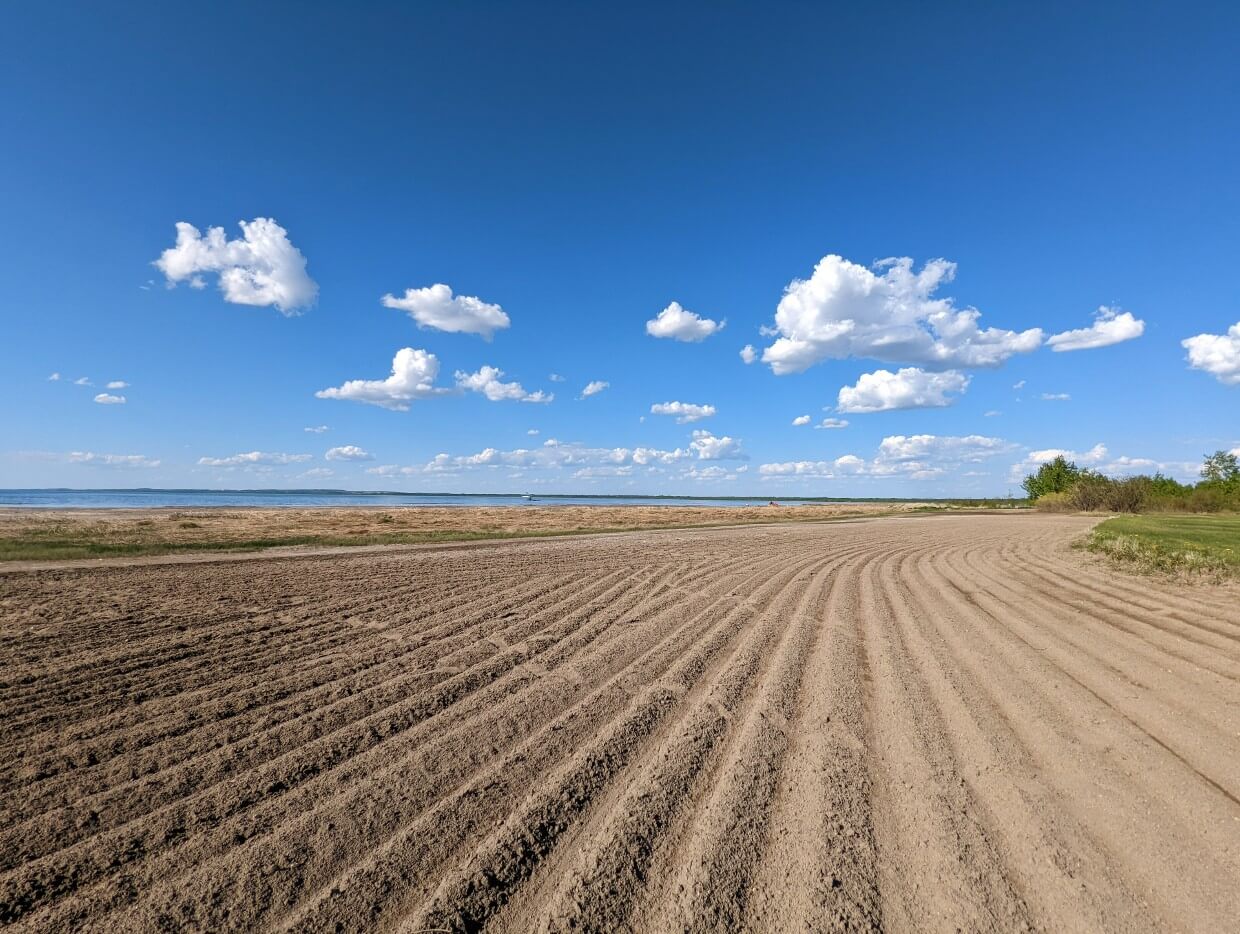 Low to the ground photo of raked sand on Gull Lake beach, Lacombe