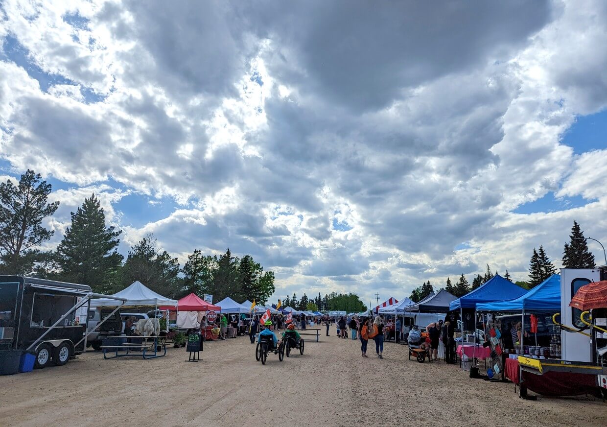 Thursday evening market in Lacombe, with many stalls on either side of the main pathway