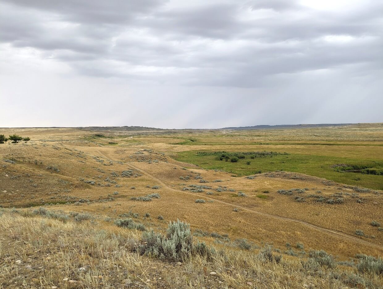 Looking down to West Block scenery with hiking trail through flat grass