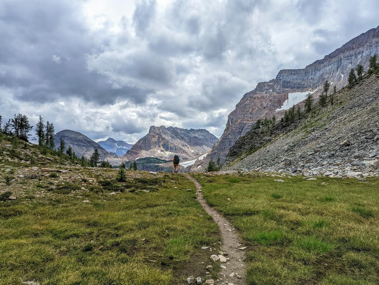 Back view of Gemma hiking Whistling Pass, with mountains on right hand side