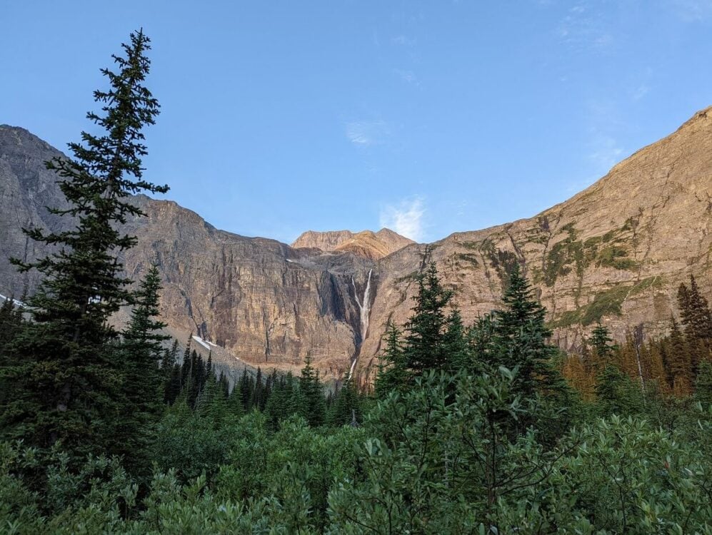 Looking up at huge waterfall cascading down amphitheater like rockface on the Rockwall Trail in Kootenay National Park