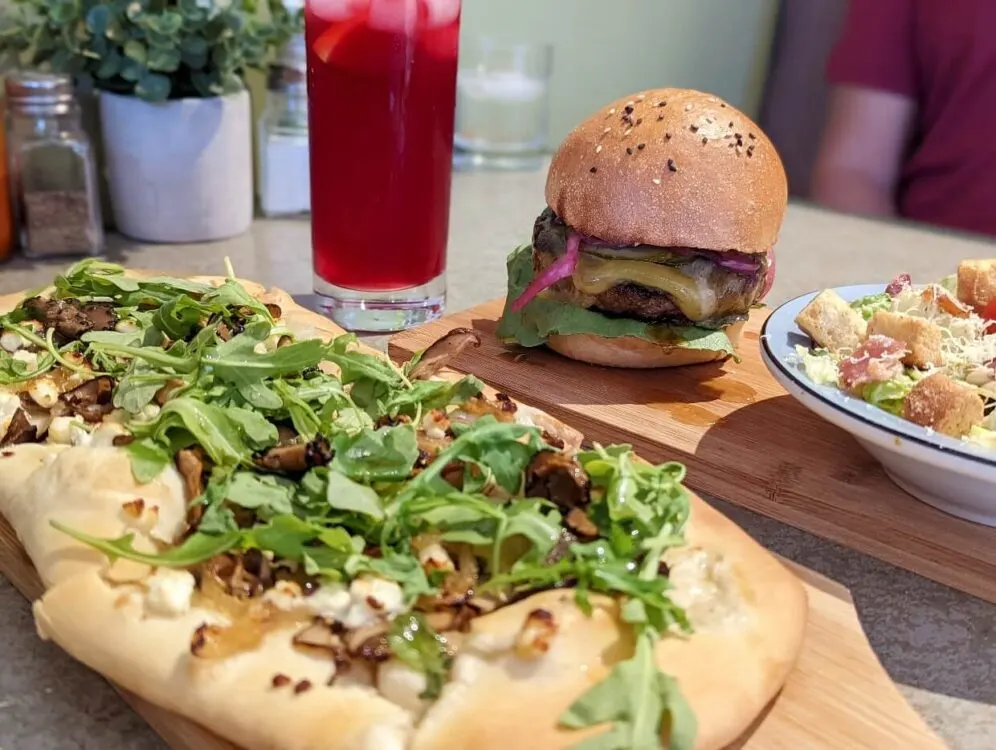 Close up of lunch at Naere Restaurant, with flatbread close to camera and burger and salad in background