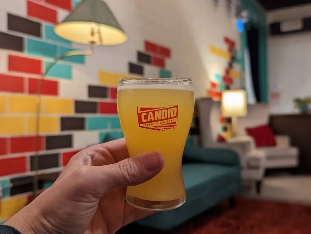 Close up of hand holding a small glass of beer at Candid Brewing - beer tasting is one of the best things to do in Antigonish