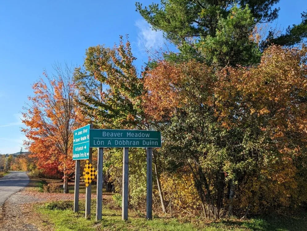 Beaver Meadow roadside in front of autumn trees, with Gaelic translation below