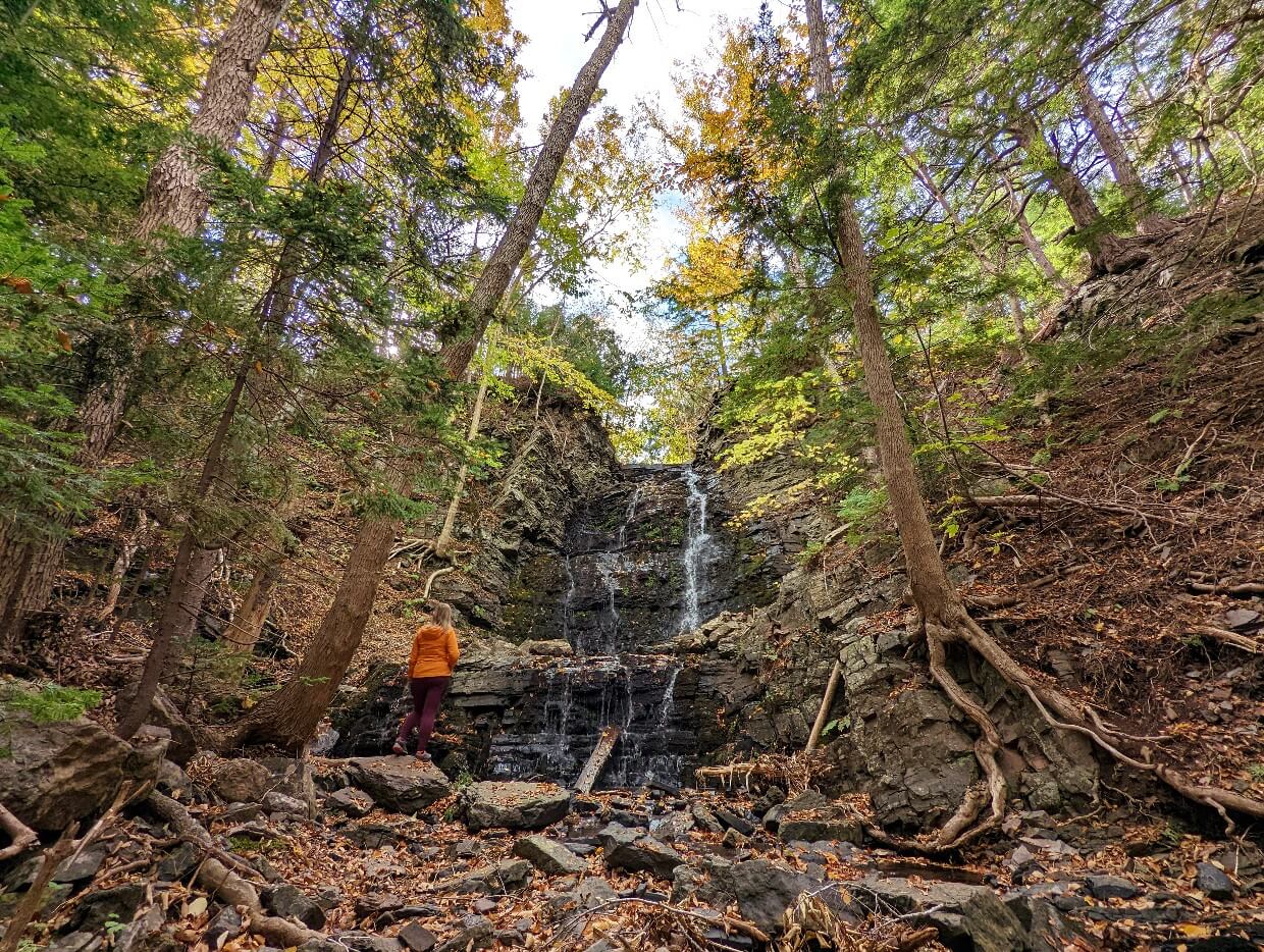 Back view of Gemma standing in front of waterfall with three levels of cascades