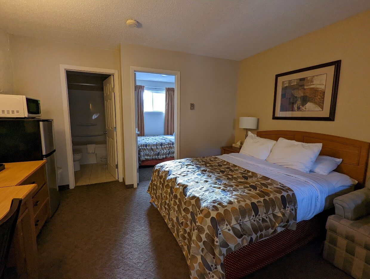 Motel room at Crystal Springs motel, with double bed in main room and another double bed in the adjoining room. A open door shows a bathroom