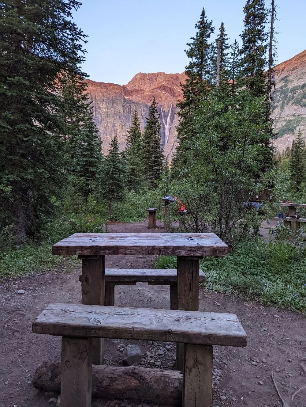 Small bench table in Helmet Falls campground cooking area, with Helmet Falls (a large cascading waterfall) visible in the background