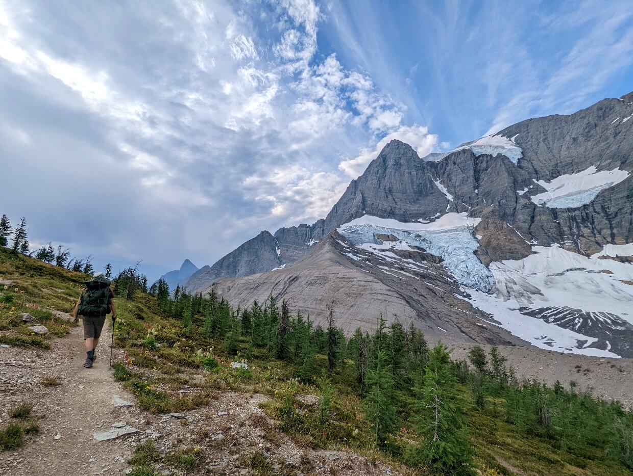 Back view of JR hiking past Tumbling Glacier on the Rockwall Trail
