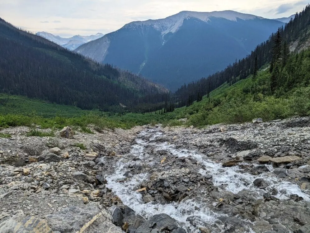 Looking down a cascading creek towards the Numa Creek river basin, with a large partially forested mountain above