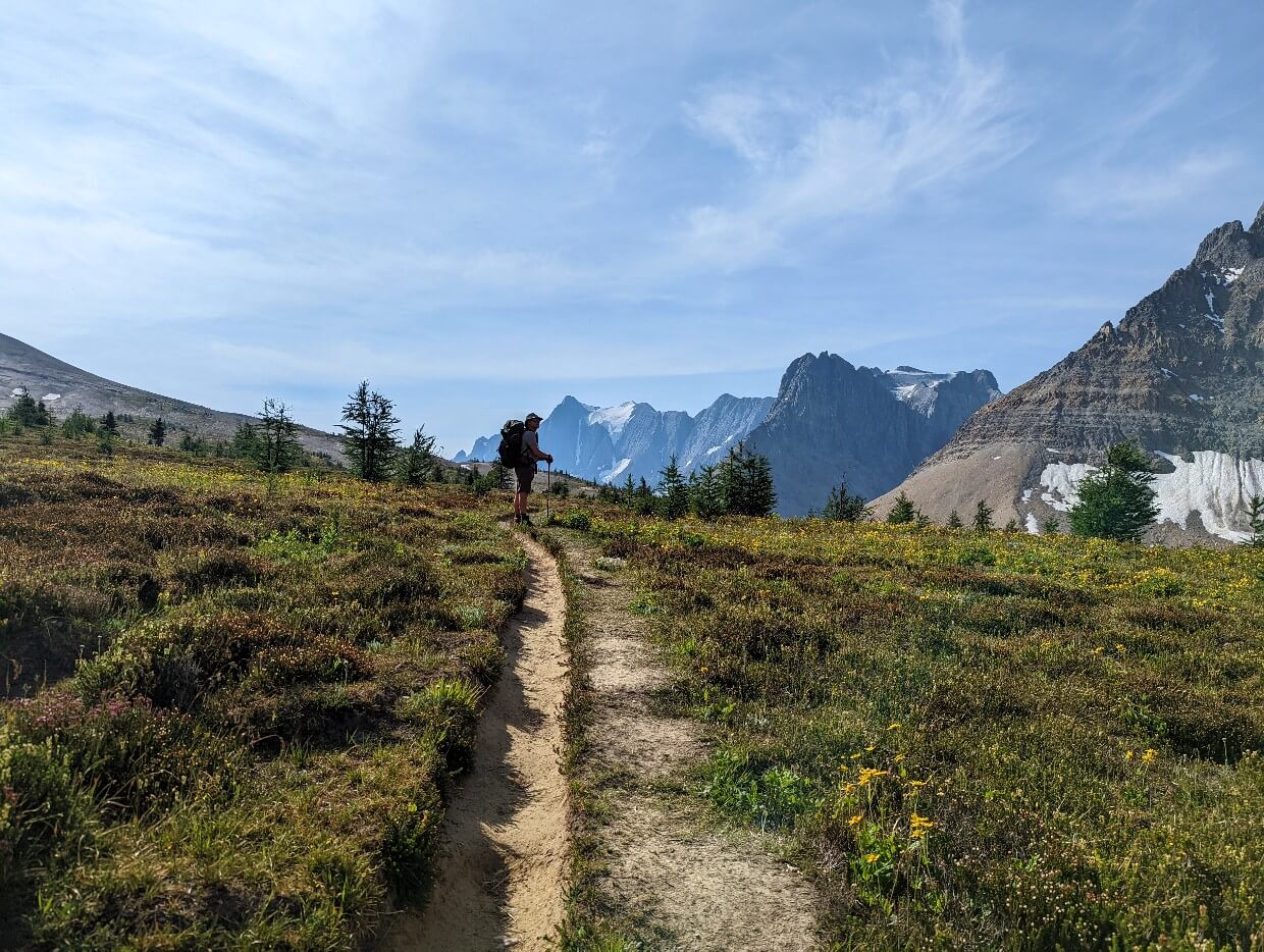 Side profile of JR standing and looking at the impressive rock cliff to the right