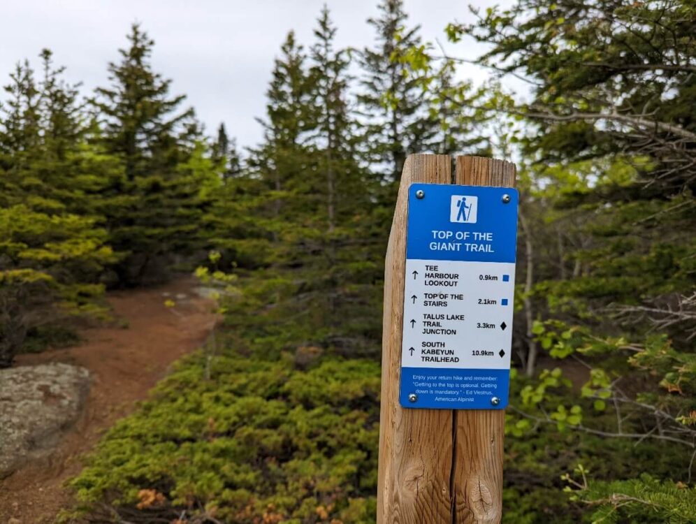 Close up of blue and white Top of the Giant Trail sign with distances to Tee Harbour Lookout and Top and the Stairs