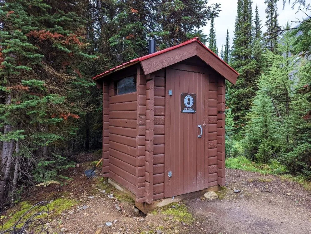 Wooden outhouse building in Mount Assiniboine Provincial Park surrounded by forest