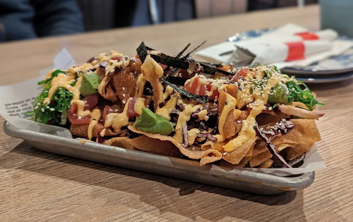 Close up of ahi tuna nachos at the Bar and Kitchen in Grand Forks, with silver plate piled with fried wontons, avocado, tuna, seaweed and mayonnaise