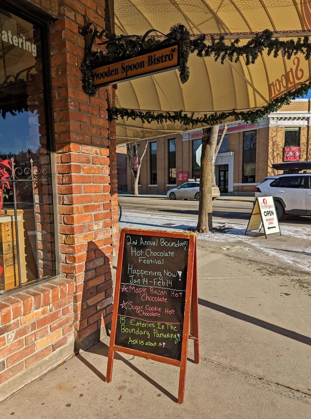 Sandwich board outside of Wooden Spoon Bistro in Grand Forks on a sunny day, promoting the 2nd Annual Hot Chocolate Festival