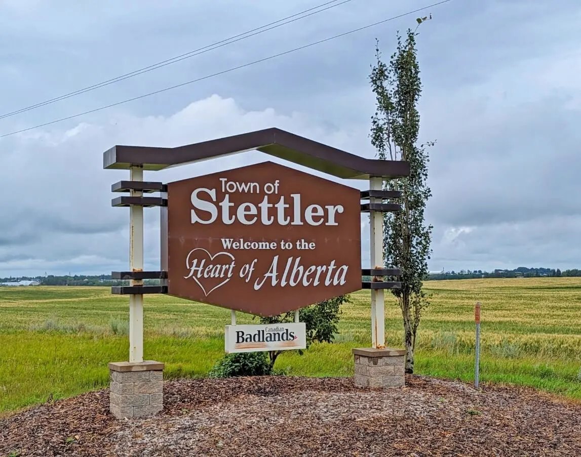 Town of Stettler welcome sign in front of green field