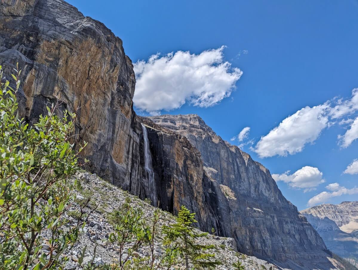 Large cascading waterfall dropping from steep cliffs on left