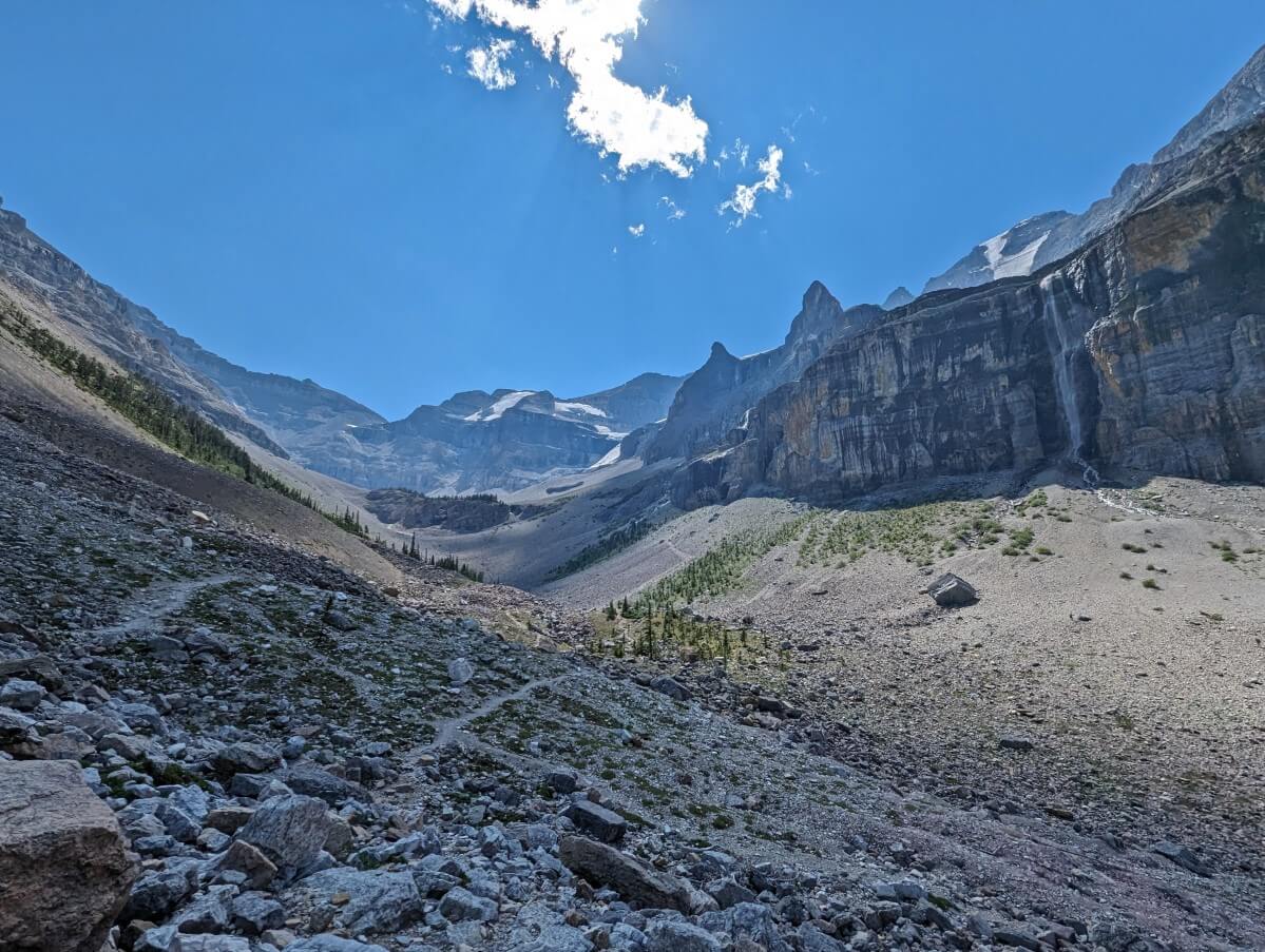 Looking ahead to trail split with upper and lower path through boulderfield. There is a large waterfall on the right and a glacier viuible in the background