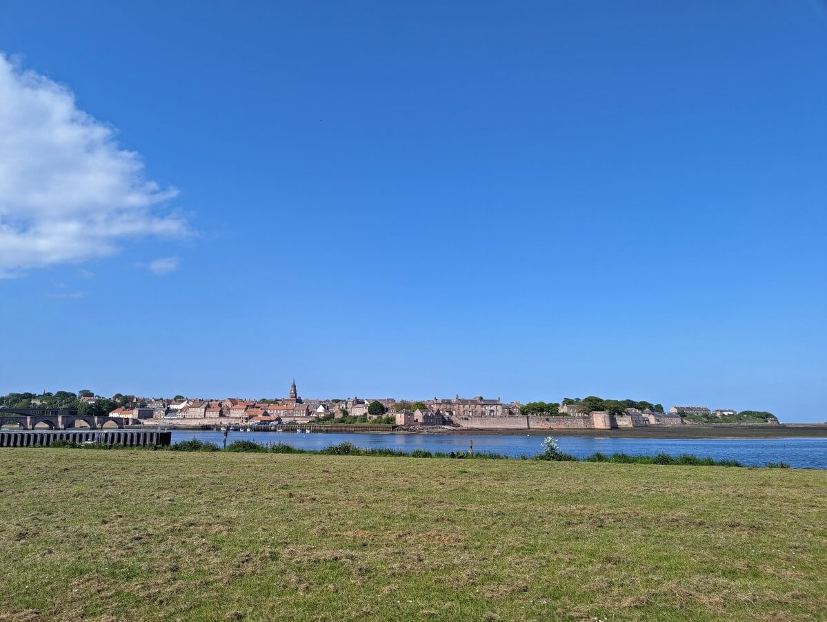 Looking across grassy field towards walled town of Berwick-upon-Tweed, which sits on the other side of the river