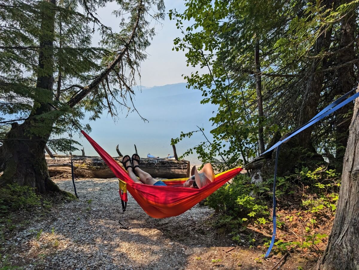 Person in a colourful hammock with a view of Azure Lake