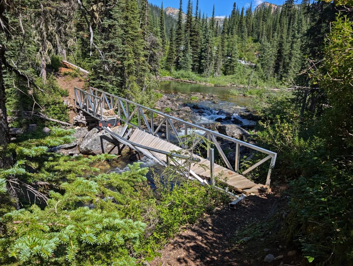 Broken metal bridge across creek between Little Peters and Big Peters lakes. The bridge is high above the river