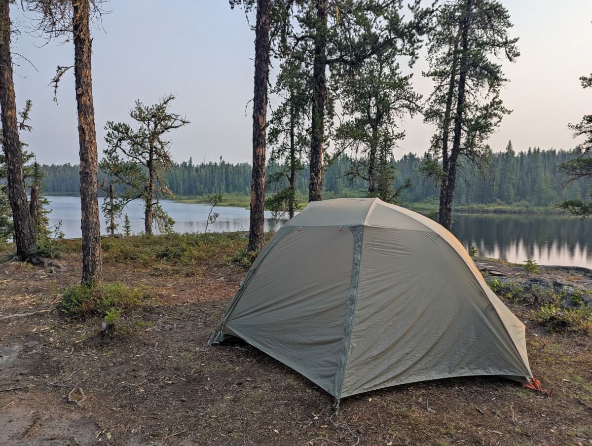 Set up tent on flat area on elevated area above lake in Wabakimi Provincial Park