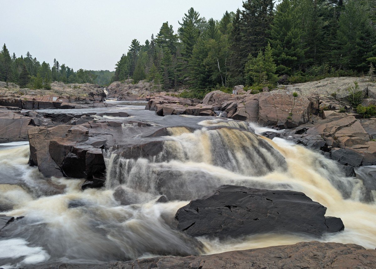 Close up of chutes and rapids in Cascades Conservation Park, surrounded by rugged rocky shore