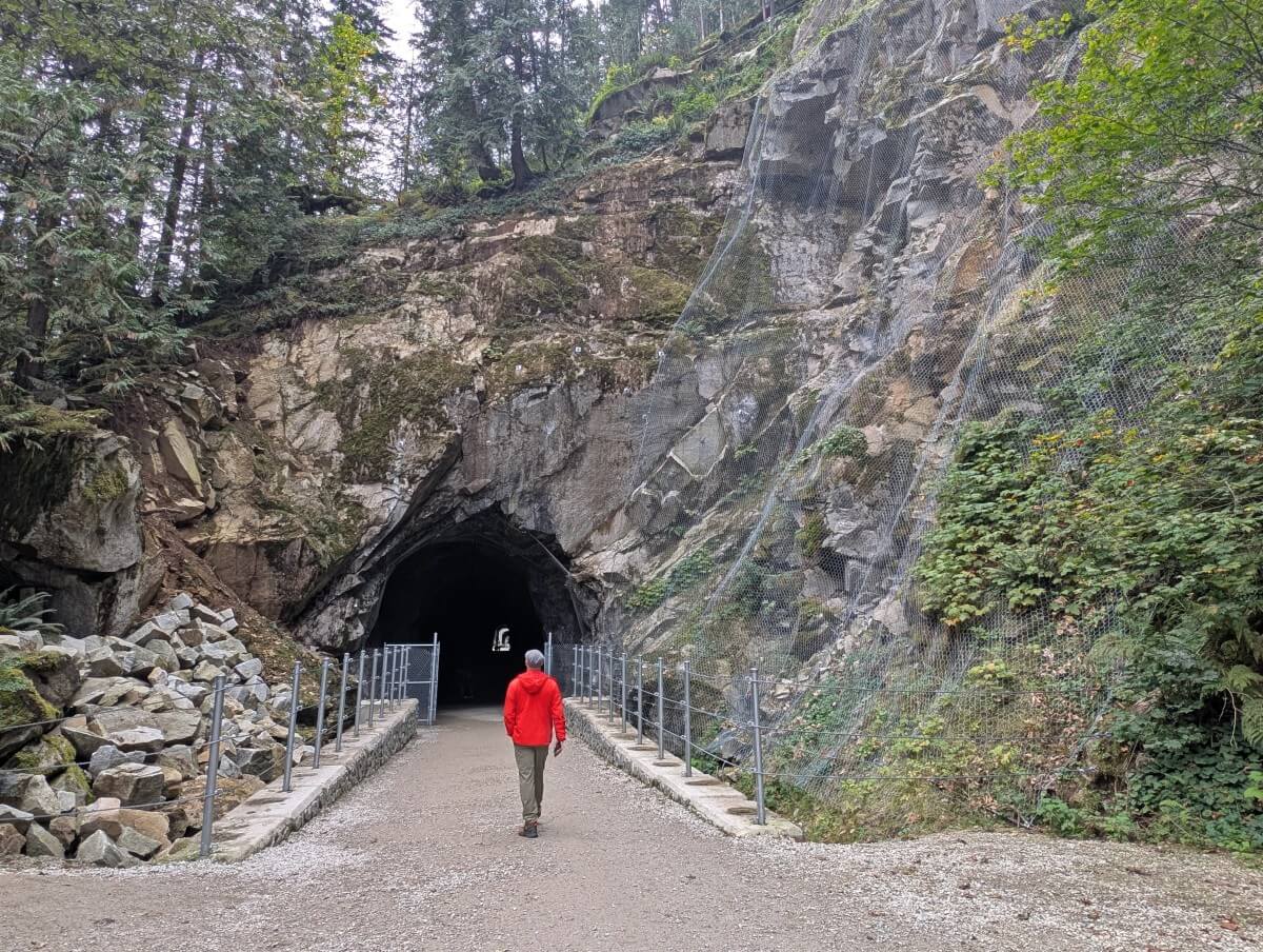 Back view of JR walking towards the first Othello Tunnel, a blasted entrance into the side of a granite headwall
