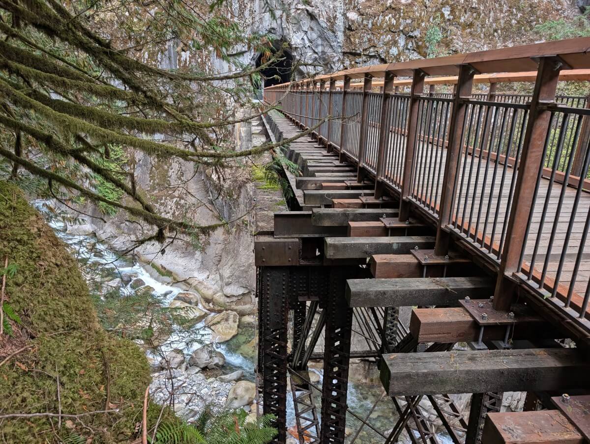 Side view of Othello Tunnels bridge, with metal railway trestle underneath, with turquoise river far below