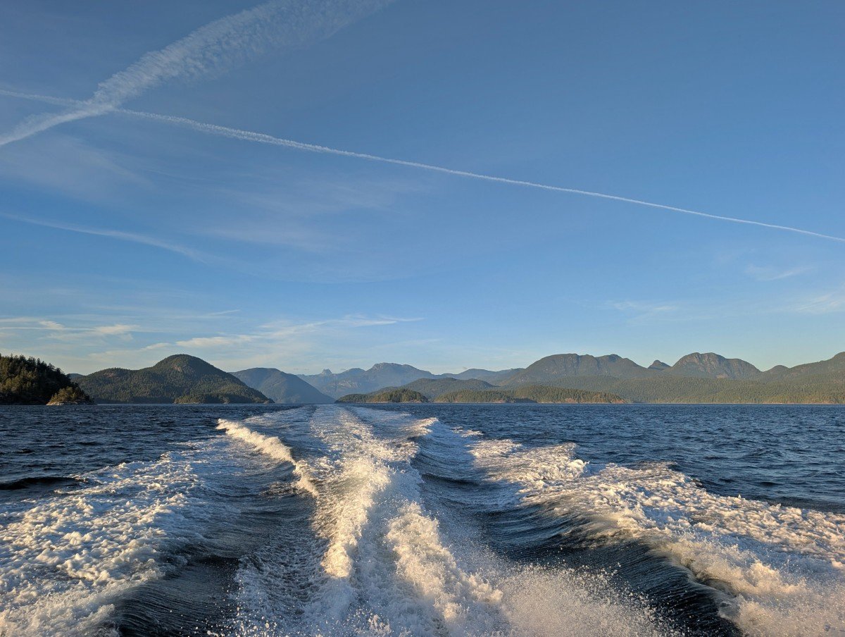 Looking behind the boat on the way back to Campbell River, with boat slipstream in front of forested mountain views