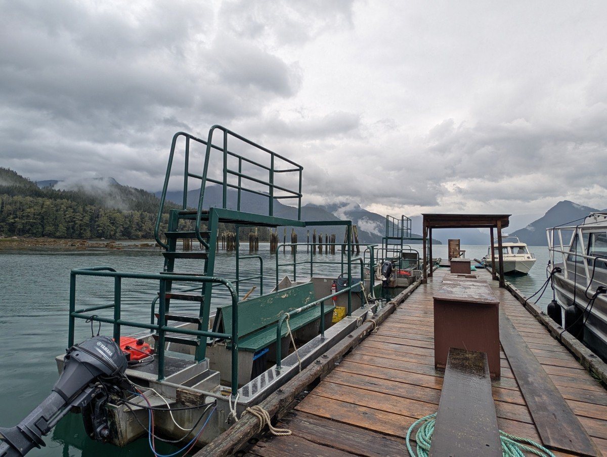 Side view of Tide Rip bear viewing skiff, a two level shallow open boat with bench seating on the lower level.