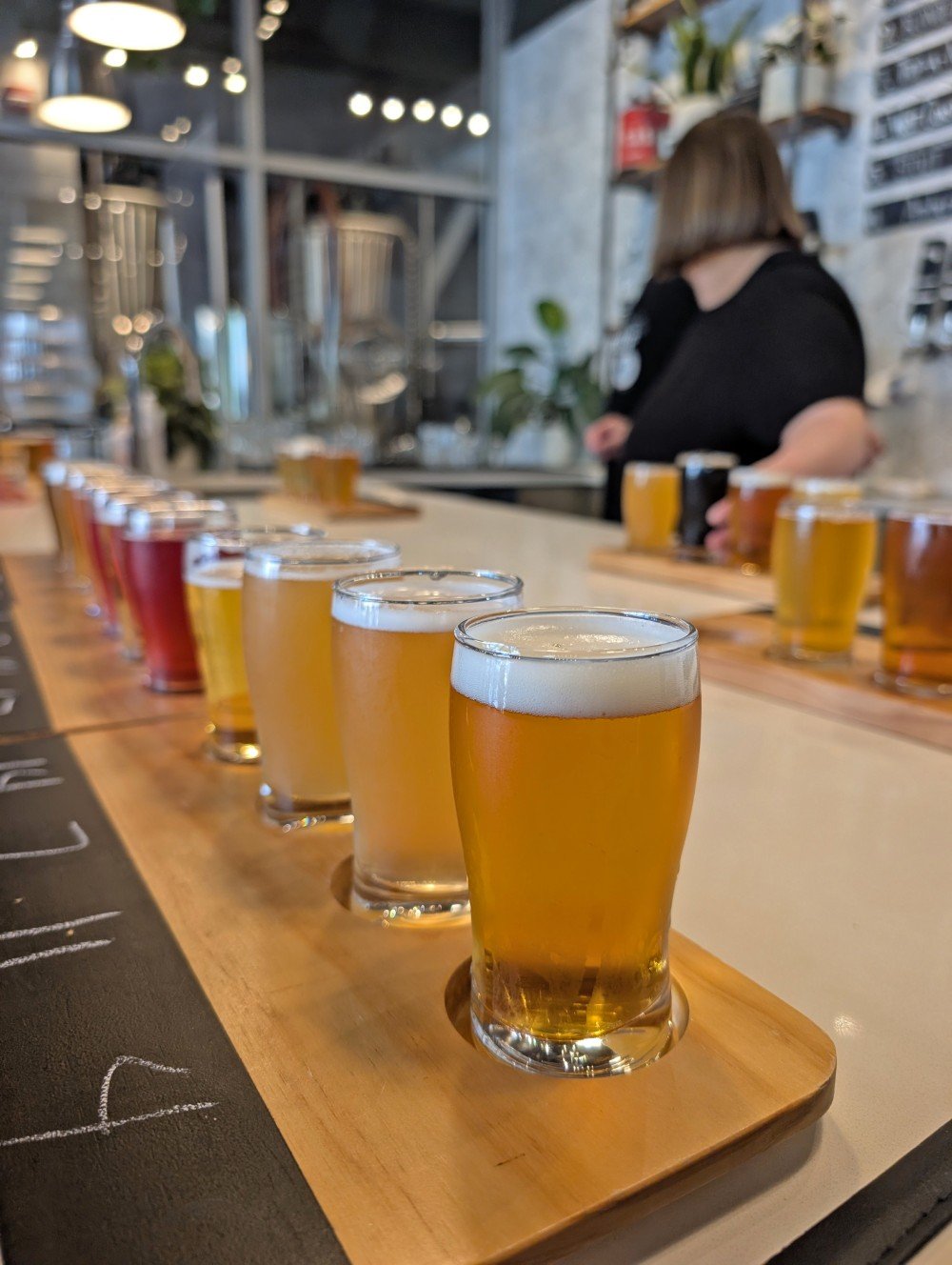 Close up of a flight of light coloured beers on the bar at Better Brother Brewing