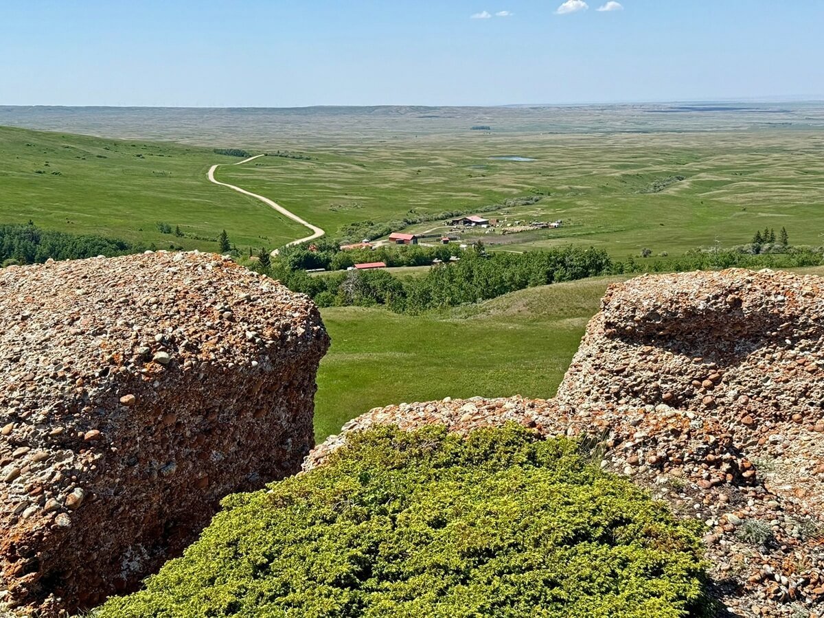 Looking through large conglomerate cliffs towards open, flat prairie landscape in Saskatchewan. Photo by Sue and Dave Slaght