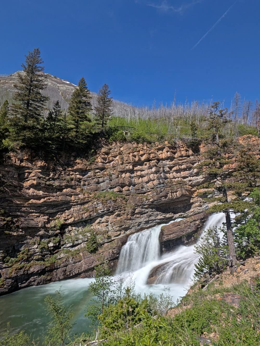 Side view of Cameron Falls, a multi level waterfall in a rugged canyon in Waterton National Park