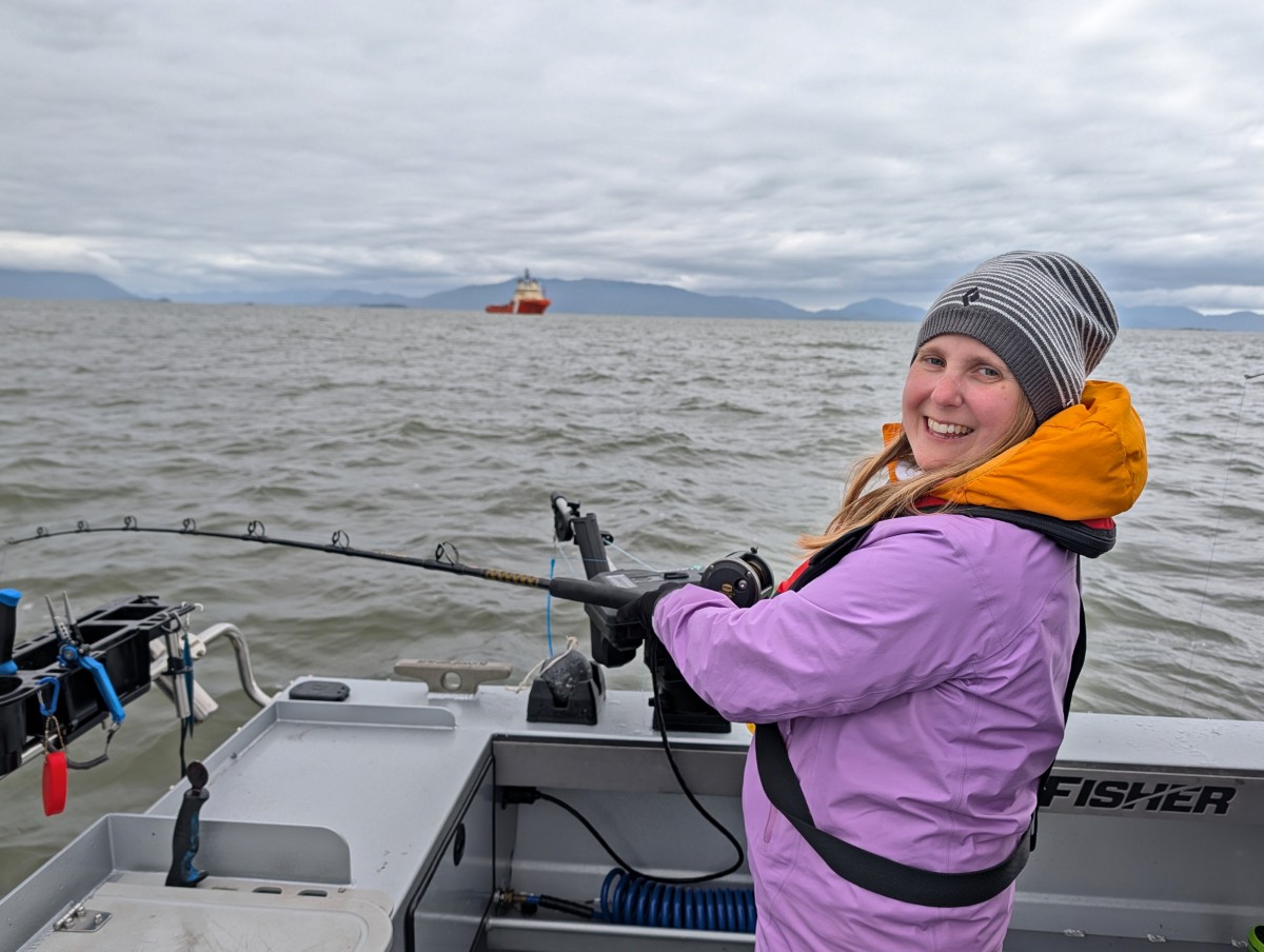 Side view of Gemma fishing on Thin Blue Lines Fishing Charters, on grey day in Prince Rupert