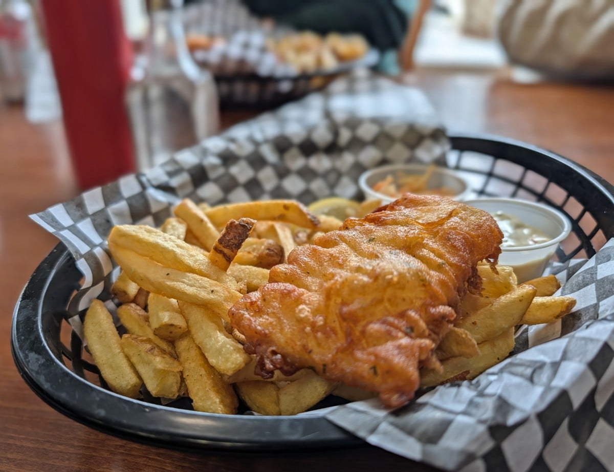 Front view of fish and chips basket at Dolly's Fish Market in Prince Rupert, a pile of fries with fried fish on top
