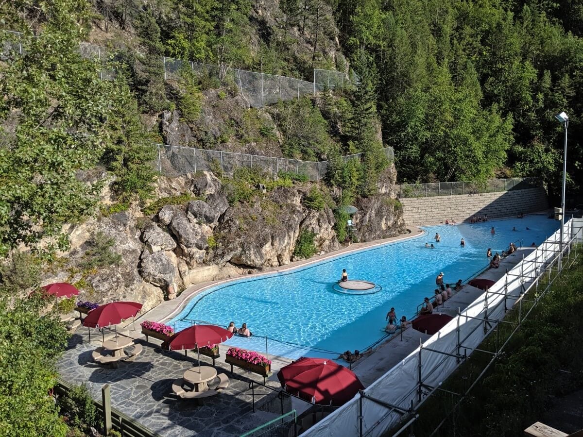 Looking over large hot springs pool at Radium with steep canyon walls to left