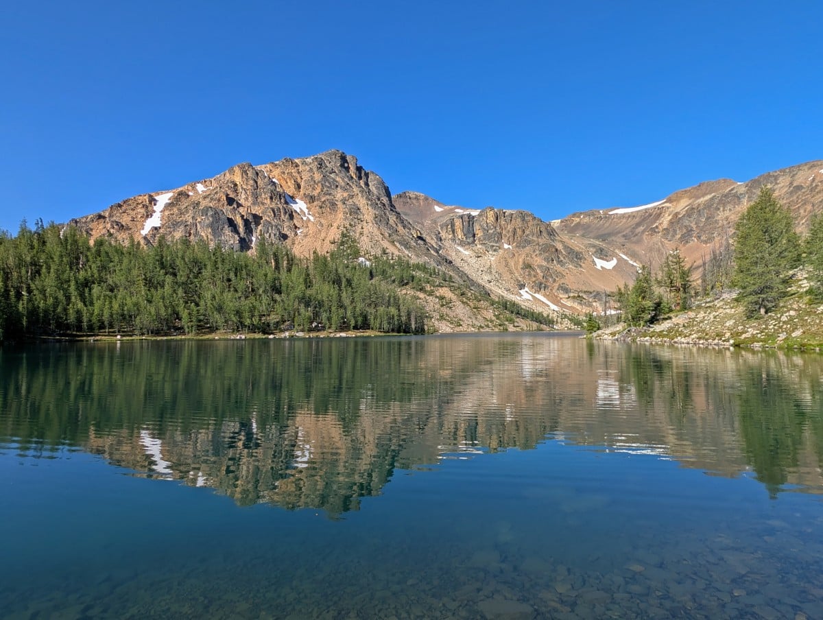 Calm reflections on a sunny day on Ladyslipper Lake, backdropped by mountains