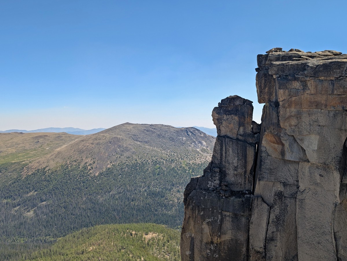 Smokey the Bear rock formation, vertical rock faces in front of mountain background